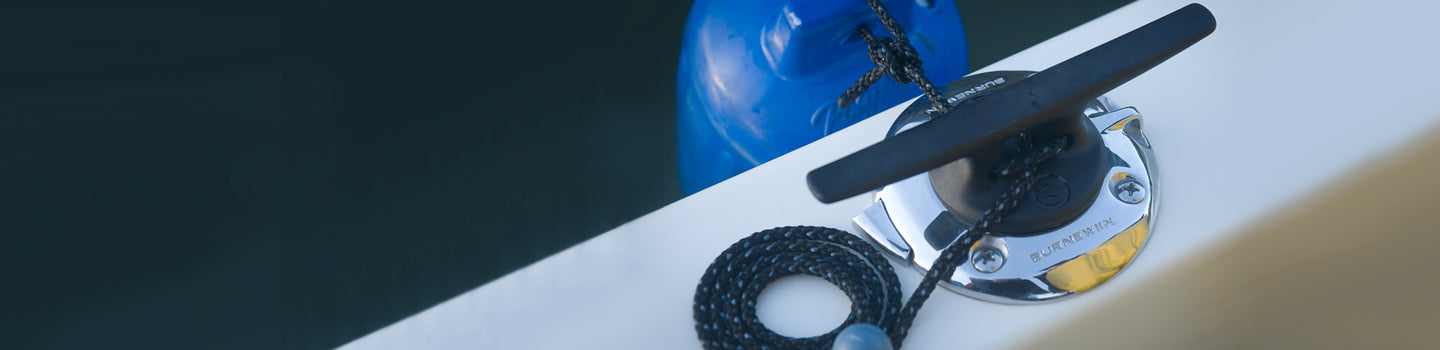The top view of a boat's port gunwale with the Burnewiin FC5120 Fender Cleat and GM650 Mount tied to a protective blue fender.