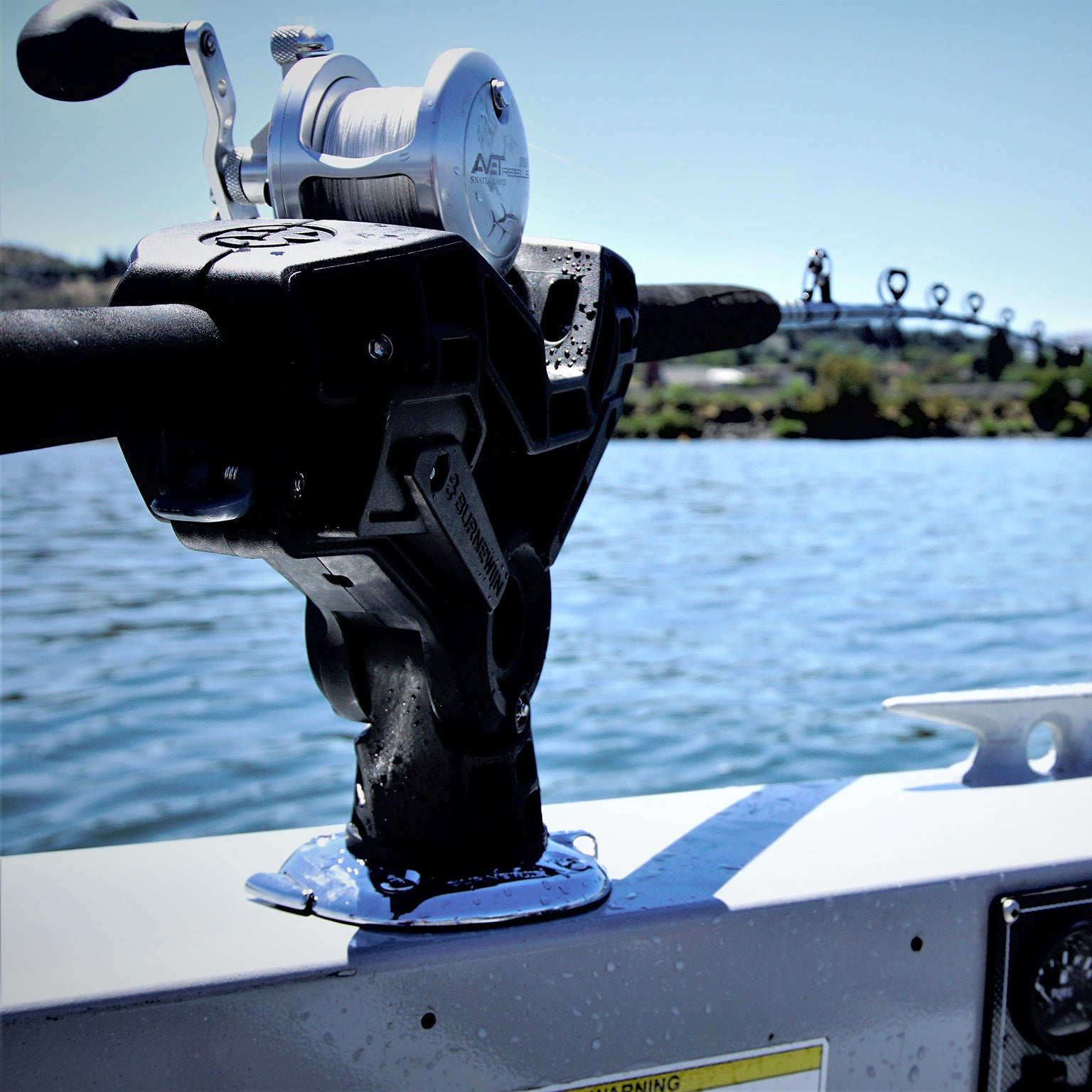 From a handle-to-tip perspective, the Burnewiin RH6650 Rod Holder containing a secured rod is mounted on the gunwale of a boat.