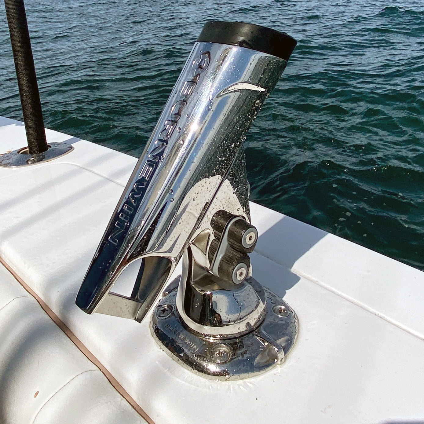 A close-up view of the Burnewiin RH8420 Stainless Steel Rod Holder inserted into the GM650 that is installed on the gunwale of a boat.