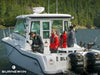 The Tofino Resort and Marina crew standing in the bow of a Boston Whaler Conquest boat outfitted with Burnewiin products. 