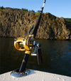 A closeup view of the Burnewiin RH5100 Flush Rod Holder mounted on the staboard gunwale and a rocky shore in the background.