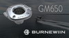 The Burnewiin GM650 stainless flush mount, above the Burnewiin Logo, and a fishing boat cruising in the background.  