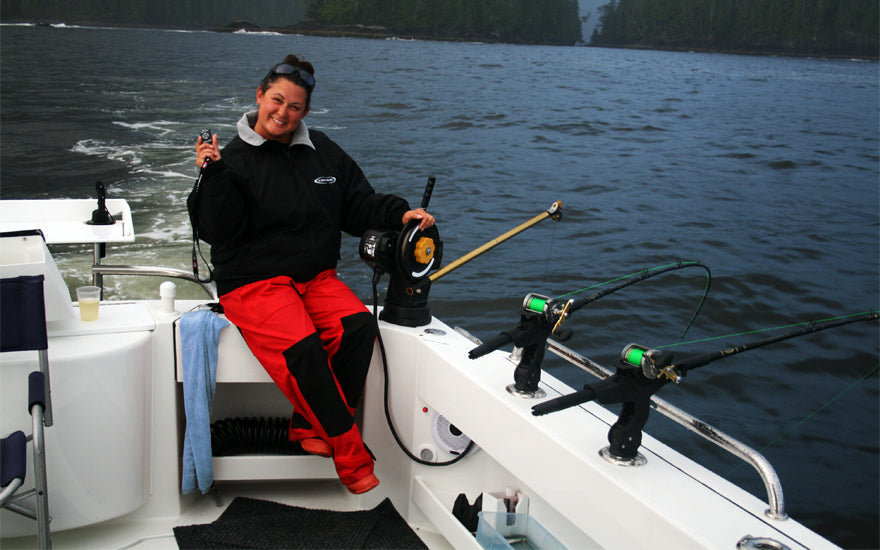 A Jubilant customer, Amanda M. Leidig from Islands Marin Center, sits on the transom of a boat with Burnewiin products.